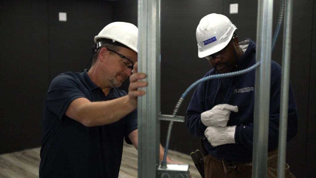 Two electricians working together on a project