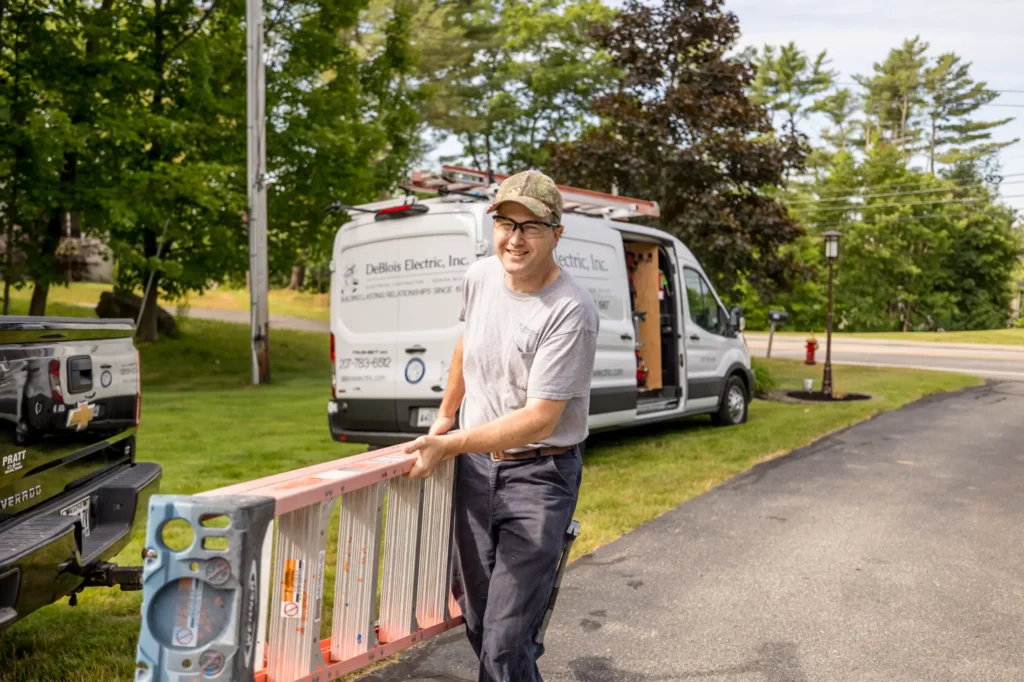 Employee carrying a ladder from work truck